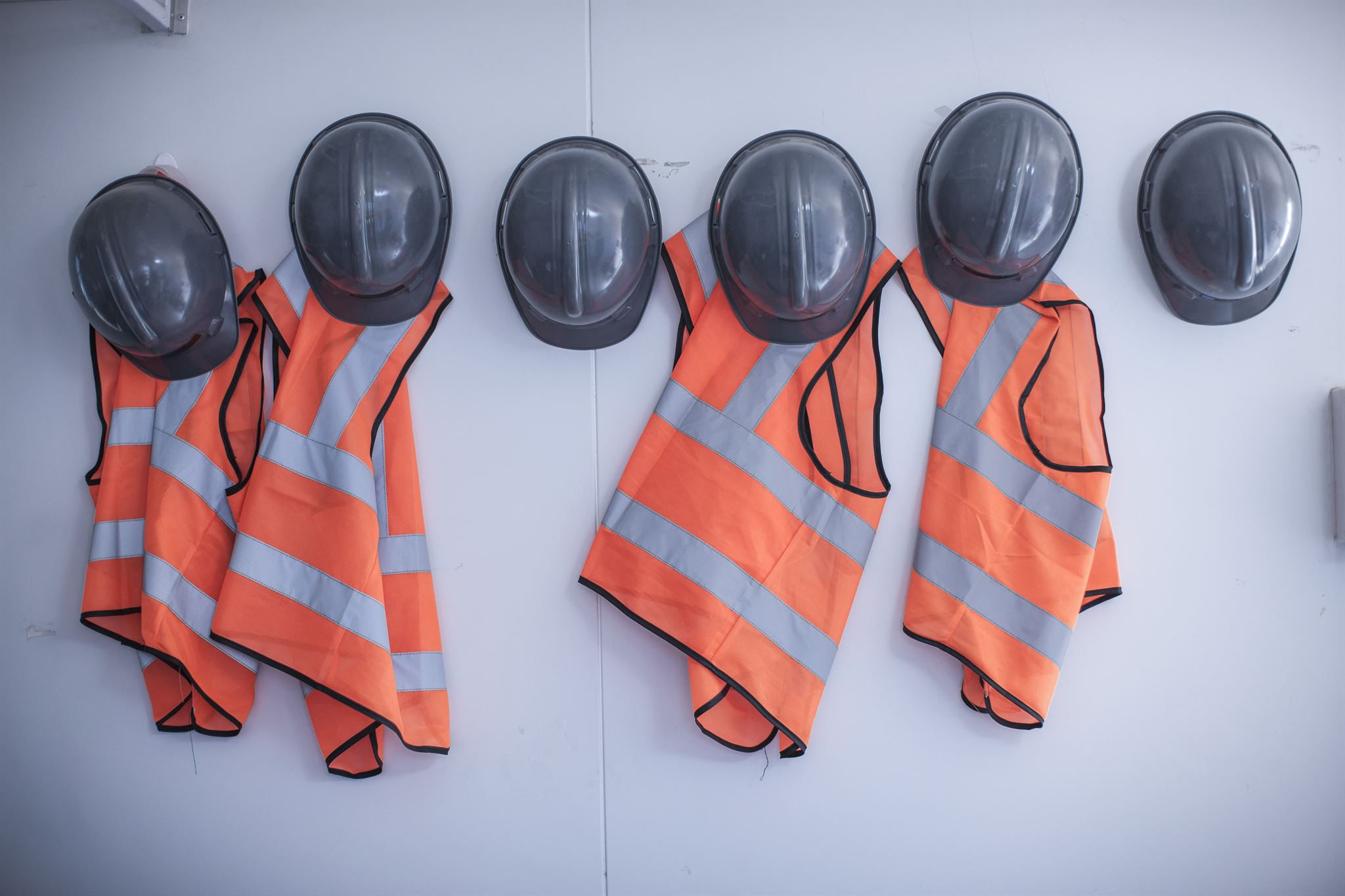 Helmen-en-veiligheidsvesten-aan-muur