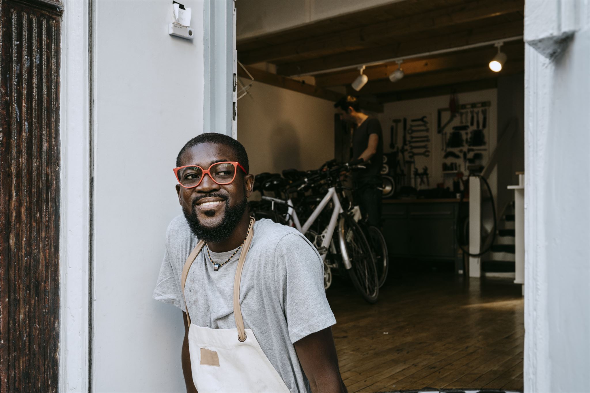 Volwassene-in-schort-die-naast-een-deur-zit